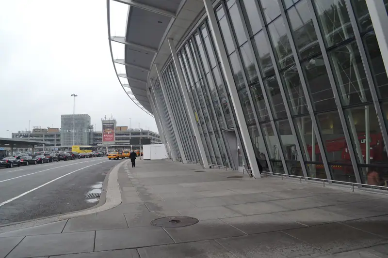 The curved glass front of JFK Terminal 4 along the departures road