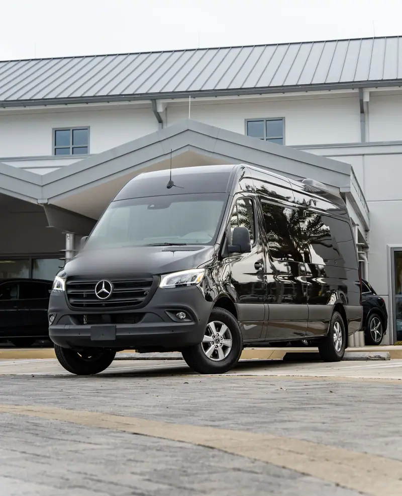 A black Mercedes-Benz Sprinter van parked outside a building